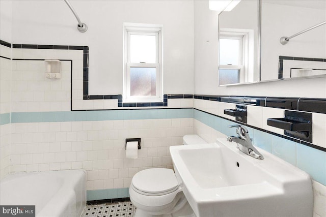 bathroom featuring sink, tile walls, tile patterned flooring, toilet, and a bath