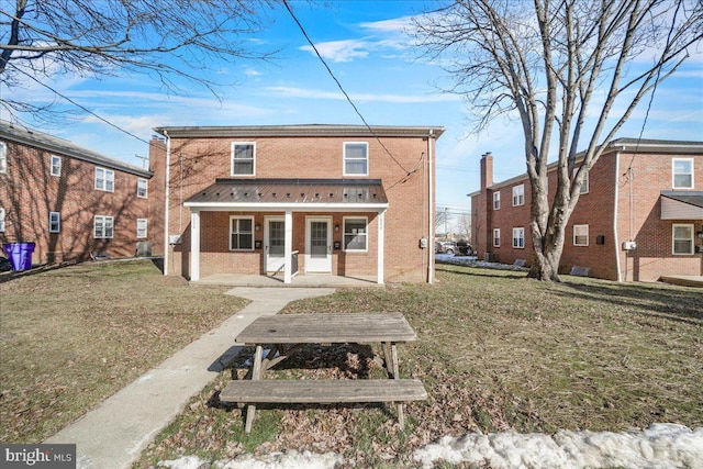 rear view of house with a porch and a lawn