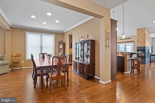 dining area featuring crown molding, baseboards, and wood finished floors