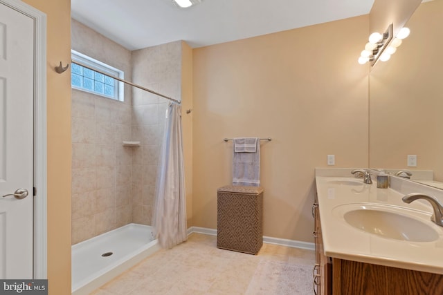 bathroom featuring a sink, baseboards, and a tile shower