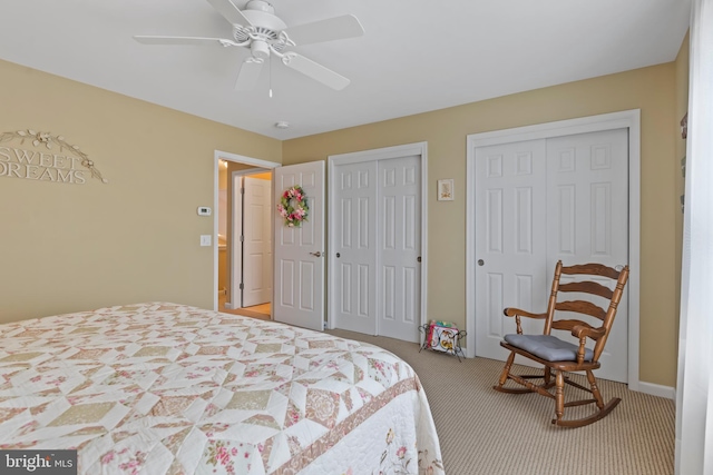 bedroom featuring a ceiling fan, carpet, and multiple closets