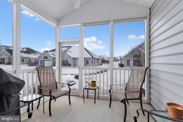 sunroom / solarium with a residential view and lofted ceiling