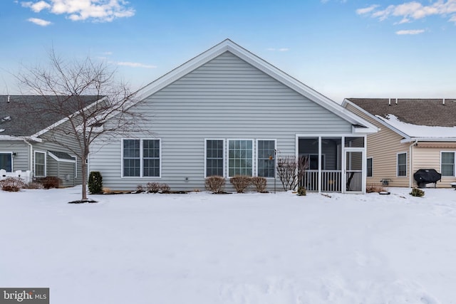 snow covered property with a sunroom