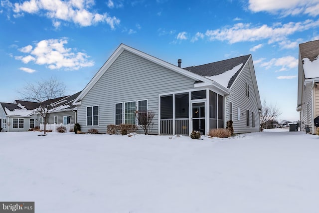 snow covered property with a sunroom