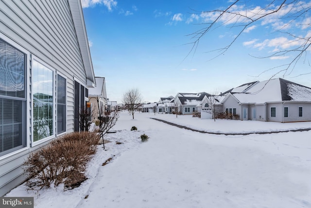 yard layered in snow with a residential view