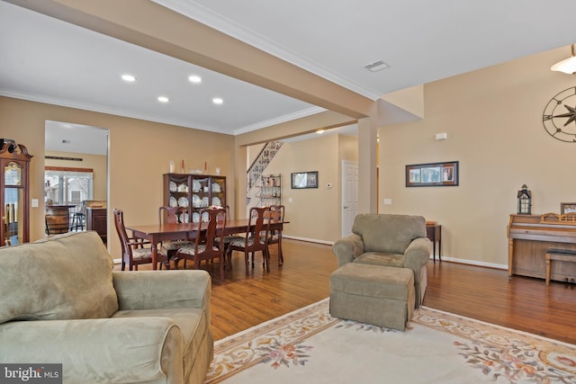 living room featuring crown molding, wood finished floors, visible vents, and baseboards