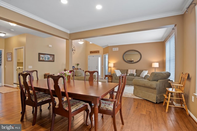 dining room with visible vents, crown molding, light wood-type flooring, and baseboards