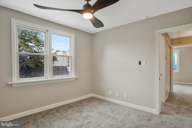 carpeted spare room featuring ceiling fan