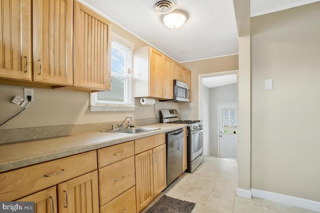 kitchen with light tile patterned flooring, appliances with stainless steel finishes, sink, and light brown cabinets