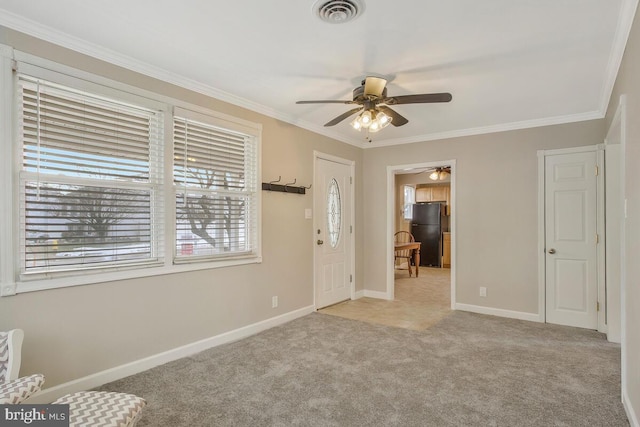 carpeted entrance foyer with ornamental molding and ceiling fan