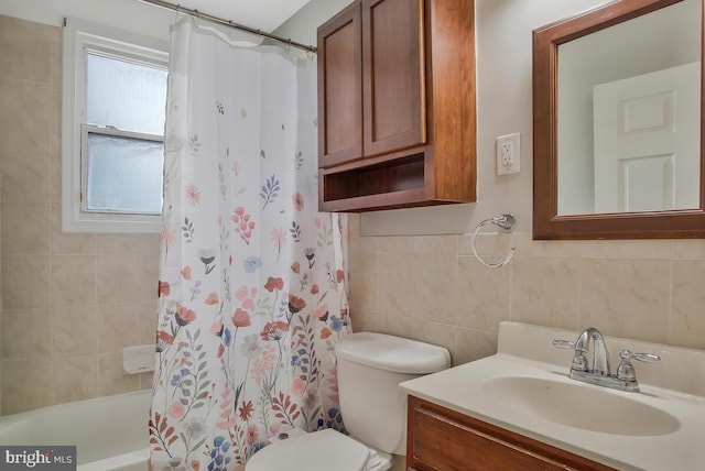 full bathroom with vanity, tile walls, shower / tub combo with curtain, and toilet