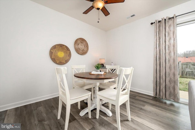 dining space with dark hardwood / wood-style flooring and ceiling fan