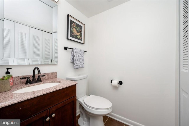 bathroom with tile patterned flooring, vanity, and toilet