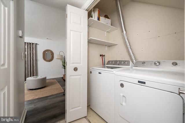 clothes washing area featuring washing machine and clothes dryer and light hardwood / wood-style floors