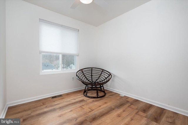 living area with hardwood / wood-style floors and ceiling fan