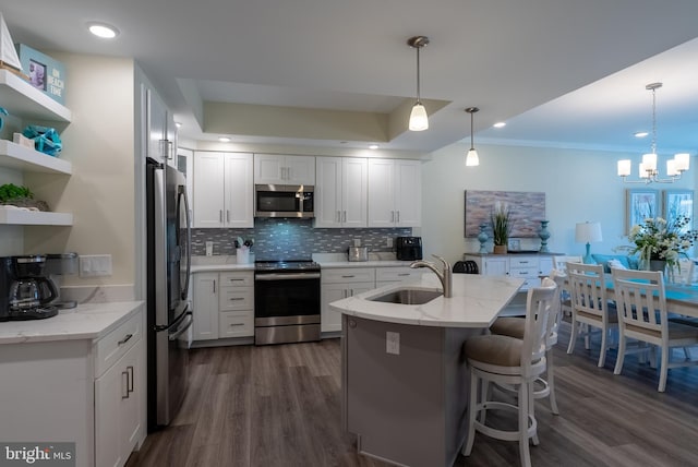 kitchen with white cabinetry, sink, light stone counters, and stainless steel appliances