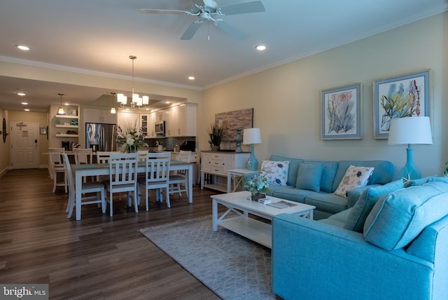 living room featuring dark hardwood / wood-style flooring, crown molding, and ceiling fan with notable chandelier