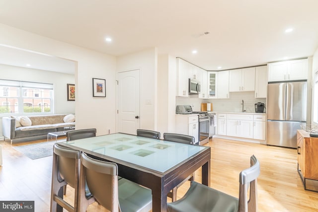 dining space featuring sink and light wood-type flooring