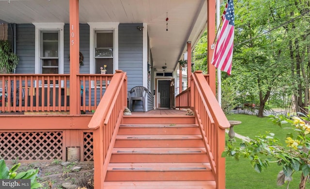 wooden deck with a lawn and a porch