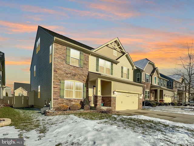 view of front of house featuring stone siding, an attached garage, driveway, and board and batten siding