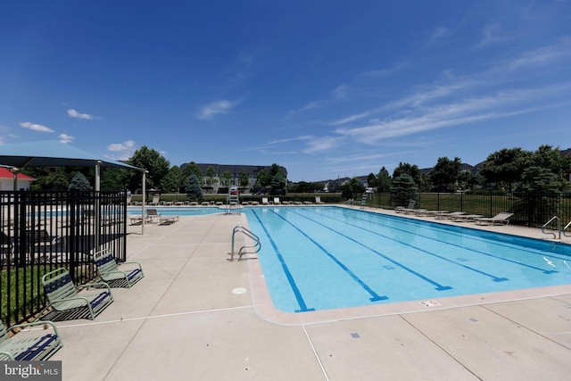 community pool featuring fence and a patio