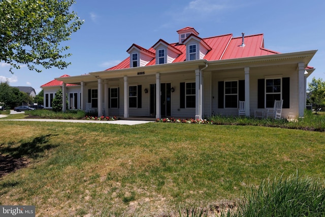 new england style home with metal roof, a porch, a standing seam roof, and a front yard