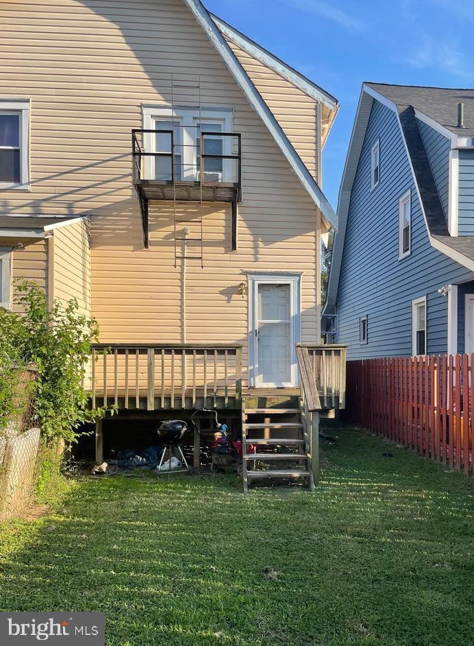 rear view of house with a wooden deck and a yard