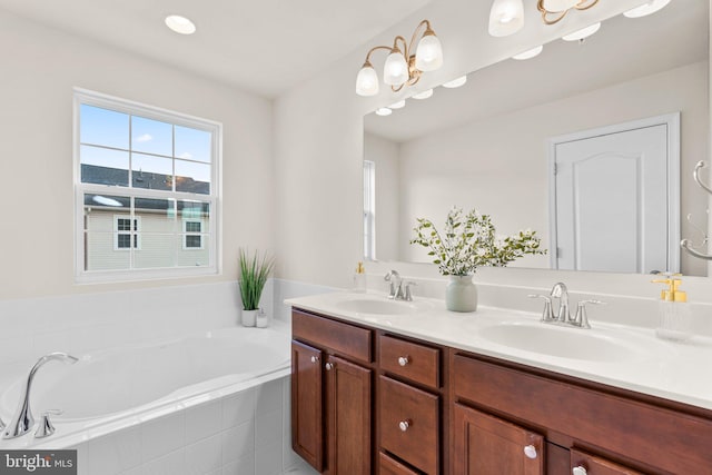 bathroom featuring a relaxing tiled tub and vanity