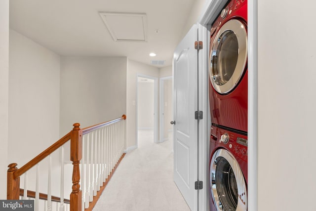 laundry room featuring stacked washer and clothes dryer and light carpet