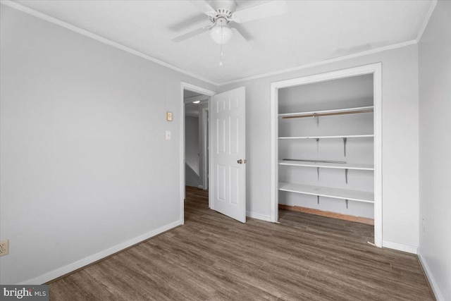 unfurnished bedroom featuring dark hardwood / wood-style flooring, crown molding, a closet, and ceiling fan