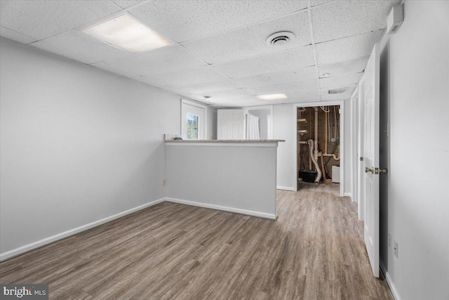 empty room with a paneled ceiling and wood-type flooring