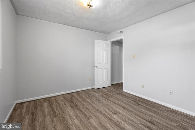 spare room with hardwood / wood-style floors and a textured ceiling