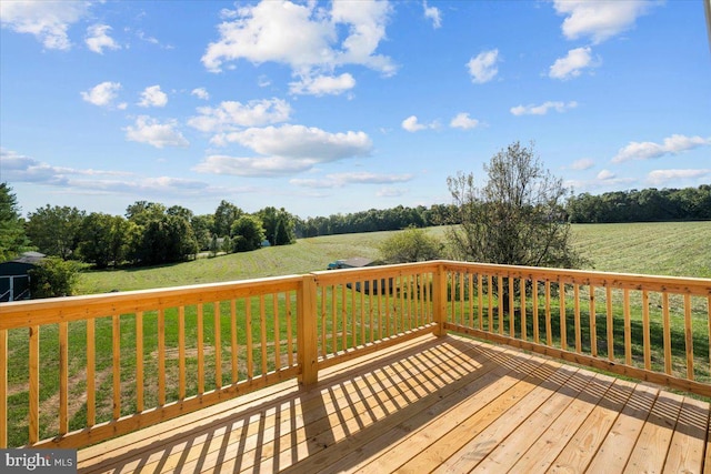 deck with a rural view and a lawn