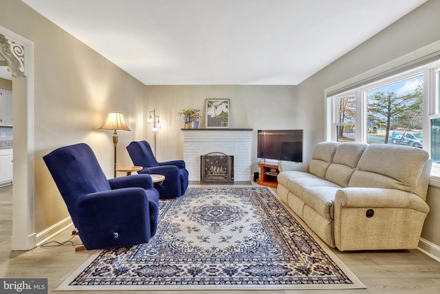 living room with a fireplace and light wood-type flooring