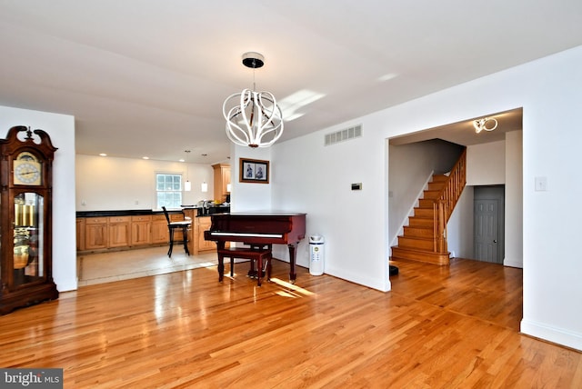 dining area with a notable chandelier and light hardwood / wood-style floors