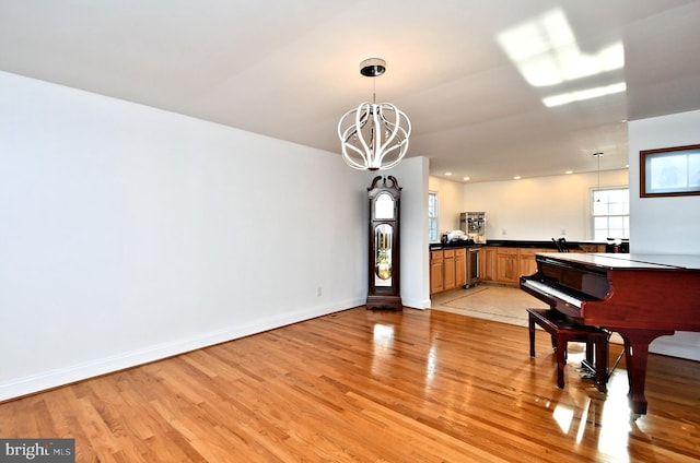 interior space featuring an inviting chandelier, beverage cooler, and light hardwood / wood-style flooring