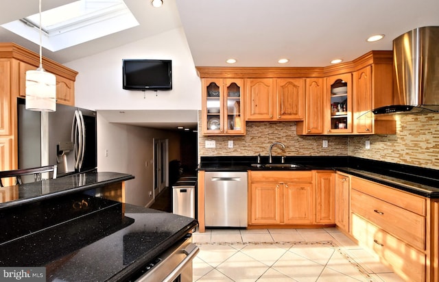 kitchen featuring sink, backsplash, lofted ceiling with skylight, stainless steel appliances, and wall chimney exhaust hood