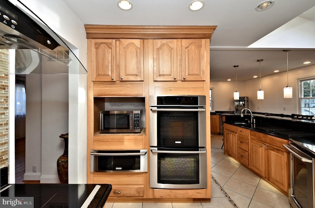 kitchen featuring light brown cabinetry, sink, decorative light fixtures, light tile patterned floors, and stainless steel appliances