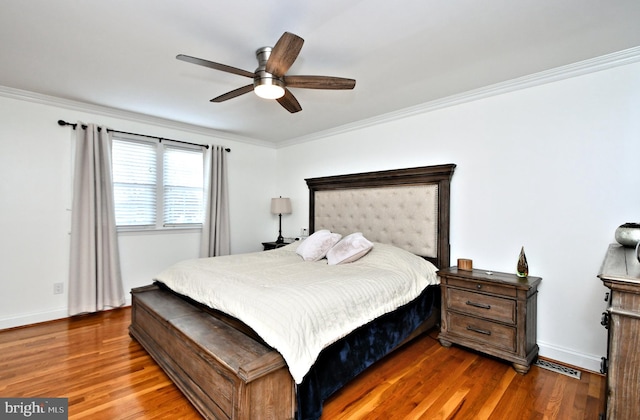 bedroom featuring dark wood-type flooring, ceiling fan, and ornamental molding