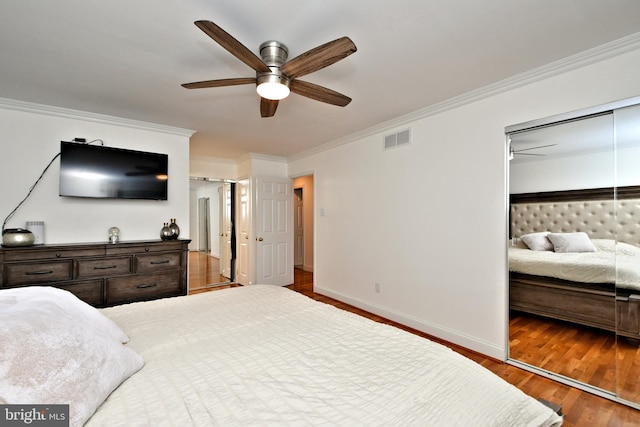 bedroom with crown molding, dark wood-type flooring, and ceiling fan