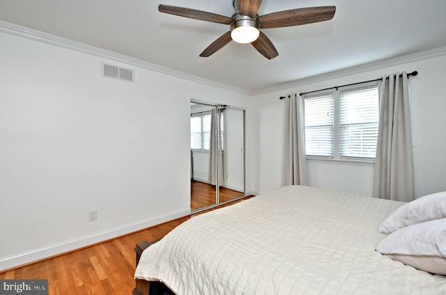 bedroom with crown molding, ceiling fan, and wood-type flooring