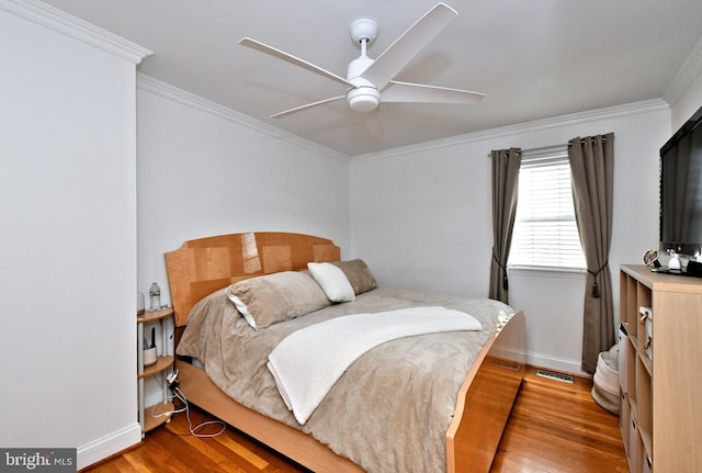 bedroom featuring hardwood / wood-style flooring, ceiling fan, and ornamental molding