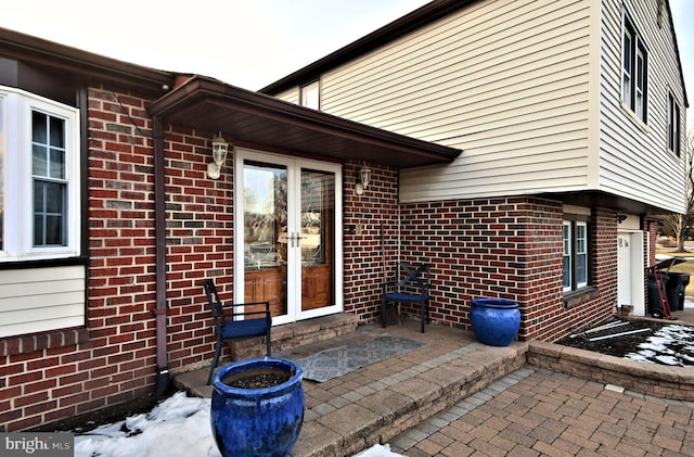 snow covered patio featuring french doors