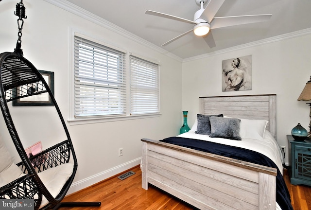 bedroom with hardwood / wood-style floors, ornamental molding, and ceiling fan