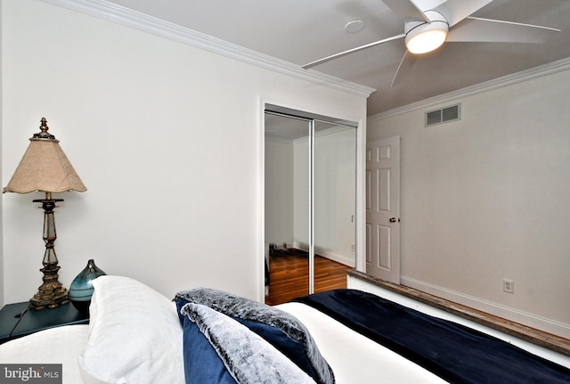 bedroom with crown molding, wood-type flooring, a closet, and ceiling fan