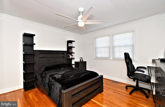 bedroom featuring hardwood / wood-style flooring, ceiling fan, and ornamental molding