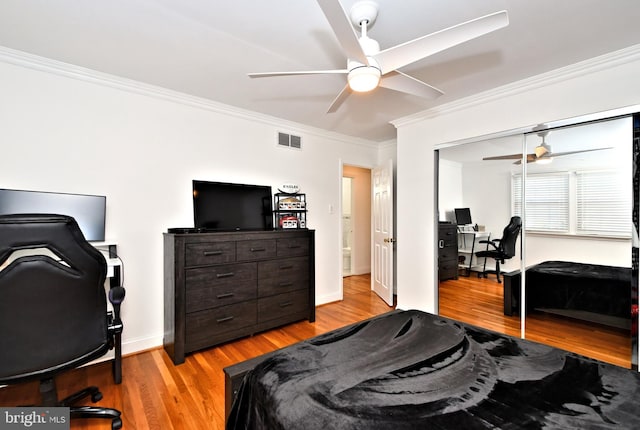 bedroom featuring crown molding, light hardwood / wood-style flooring, and a closet