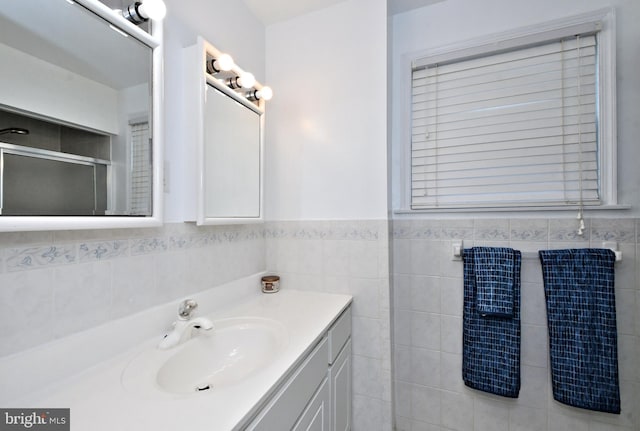 bathroom featuring vanity and tile walls