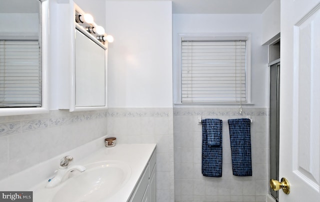 bathroom featuring vanity and tile walls