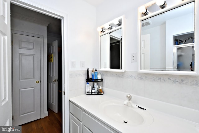 bathroom with vanity, an enclosed shower, and hardwood / wood-style floors